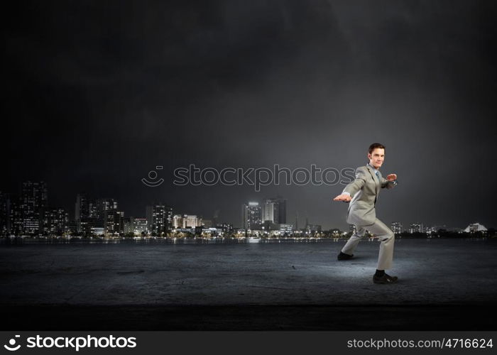 Impossible mission. Cheerful young businessman demonstrating self defence element