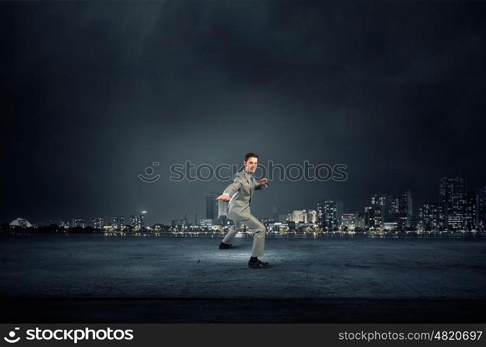Impossible mission. Cheerful young businessman demonstrating self defence element
