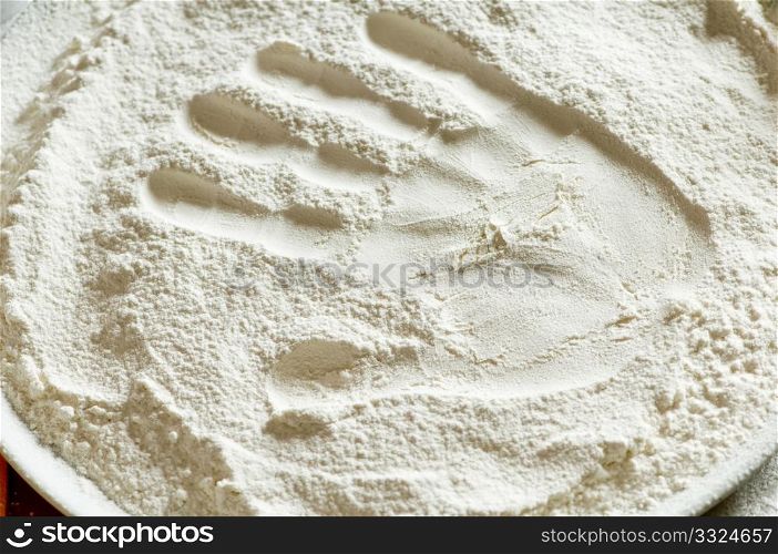 imprint of a woman&rsquo;s hand in a bowl with the flour