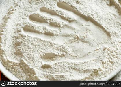 imprint of a woman&rsquo;s hand in a bowl with the flour