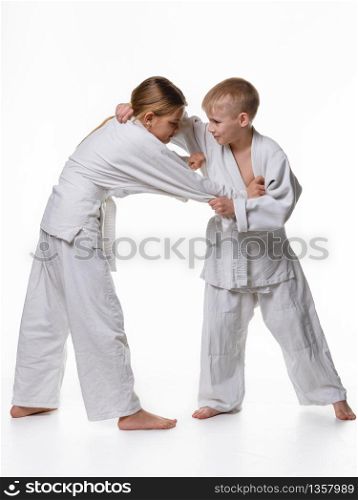 In a judo lesson, a boy and a girl fight and capture