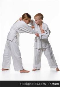 In a judo lesson, a boy and a girl fight and capture