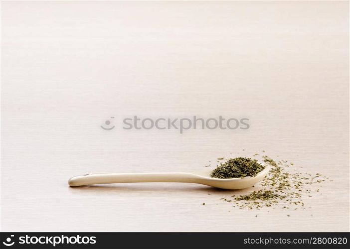 in a spoon with some spilt over the wooden background