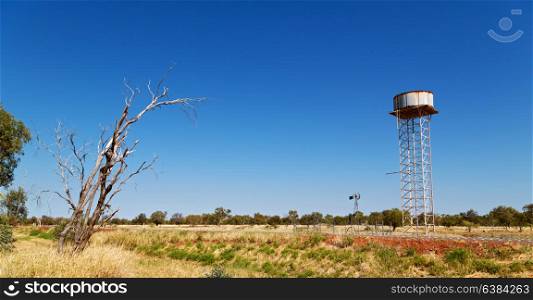 in australia the concept of remote in the outback with asphalt line and water tank