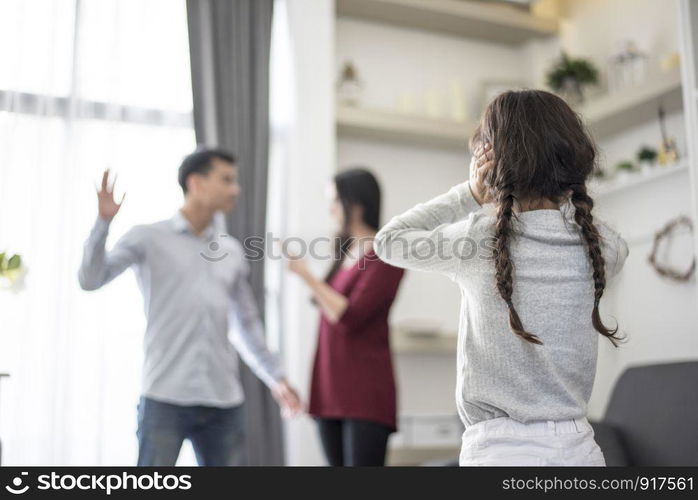 In back view, Little girl puts her hands on her ears because she does not want to hear her dad and mom quarrel. close ears, Family Dramatic scene, Parrents issues, Social and parents problem concept