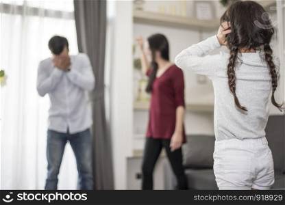 In back view, Little girl puts her hands on her ears because she does not want to hear her dad and mom quarrel. close ears, Family Dramatic scene, Parrents issues, Social and parents problem concept