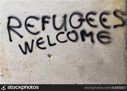 in cyprus the spray paint in the wall with refugees welcome like concept of hospitality . the spray paint in the wall with refugees welcome