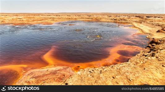 in danakil ethiopia africa the black lake with boiling oil and hot. in ethiopia africa the black lake and sky