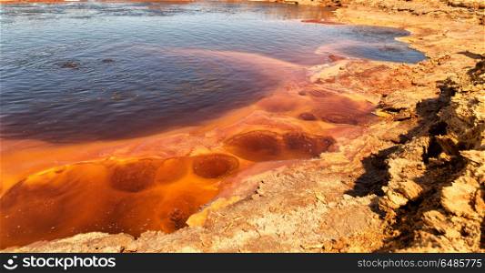 in danakil ethiopia africa the black lake with boiling oil and hot. in ethiopia africa the black lake and sky