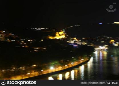 in georgia tbilisi the view of the city   near the river and old architecture in the night blur and noise
