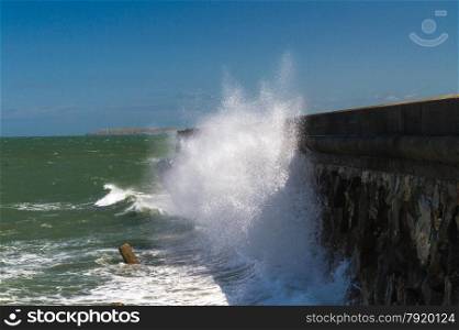 In high wind, waves crash against the Victorian Breakwater (1.7 miles long) at Holyhead, Anglesey, Wales, United Kingdom.
