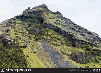 in Iceland. travel to Iceland - slope of volcanic mountains near Skogafoss waterfall in Katla Geopark on Icelandic Atlantic South Coast in september