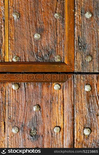 in italy patch lombardy cross castellanza blur abstract rusty brass brown knocker a door curch closed wood