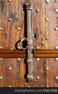 in italy patch lombardy cross milan blur abstract rusty brass brown knocker a door curch closed wood