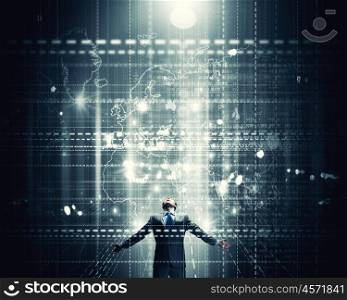 In light of success. Businessman with hands spread apart standing in light coming from above