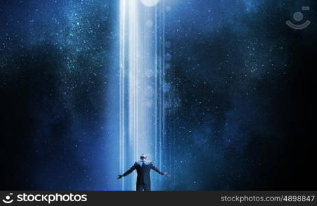 In light of success. Businessman with hands spread apart standing in light coming from above