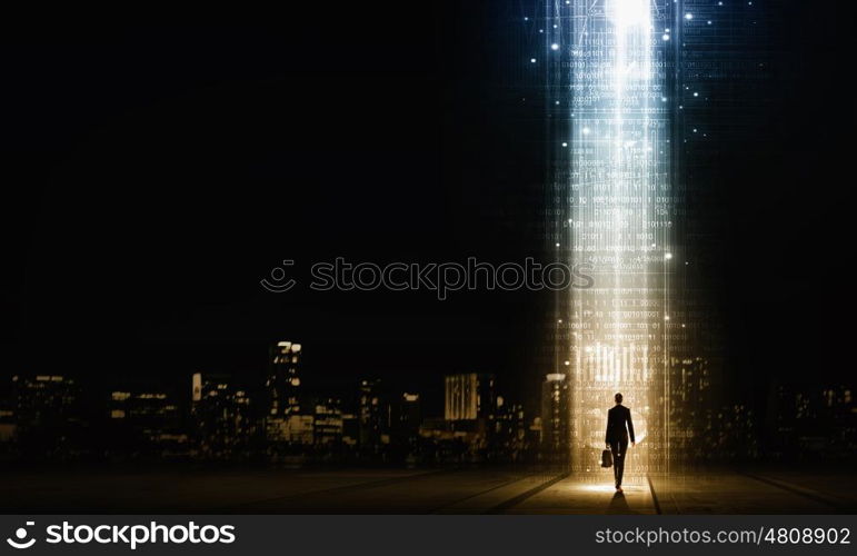 In light of success. Rear view of businesswoman standing in light going from above