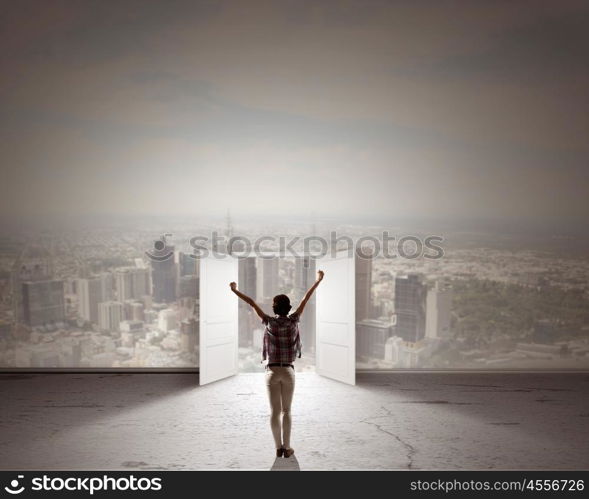 In light of success. Rear view of woman with hands up entering opened door