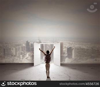 In light of success. Rear view of woman with hands up entering opened door