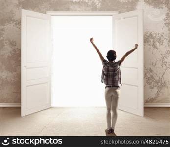 In light of success. Rear view of woman with hands up entering opened door