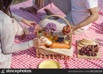 In love couple enjoying picnic time in park outdoors Picnic. happy couple relaxing together with picnic Basket.