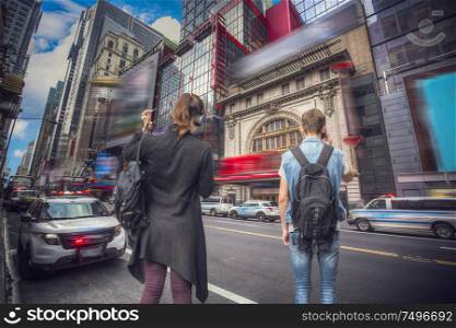 In Manhattan, a man is talking on the phone, a woman is crossing the road