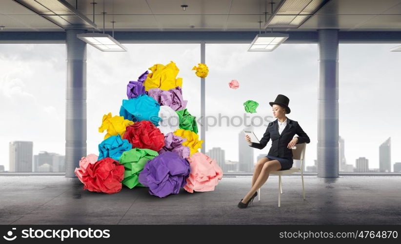 In search of good idea and inspiration. Young woman and heap of paper balls as symbol of creativity