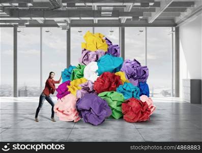 In search of good idea and inspiration. Young woman and heap of paper balls as symbol of creativity