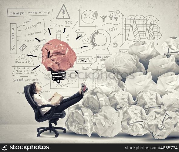In search of great idea. Businesswoman in chair and many crumpled balls of colorful paper as creativity sign