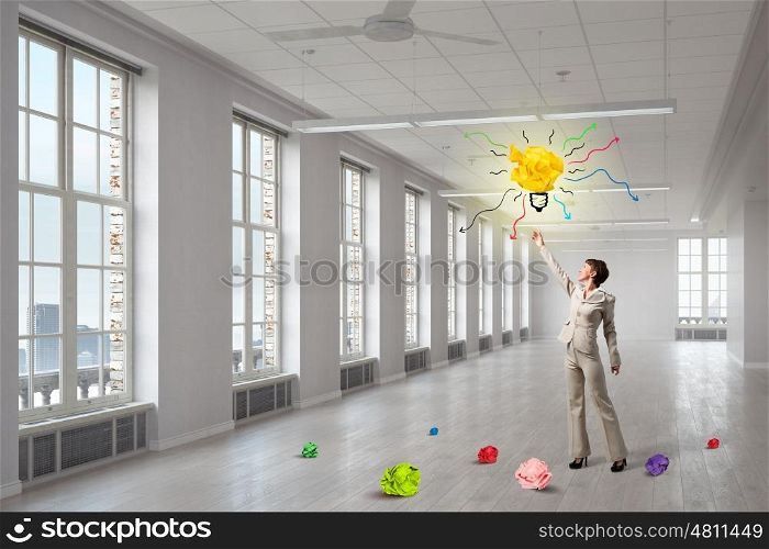 In search of inspiration. Elegant businesswoman in modern interior and balls of crumpled paper