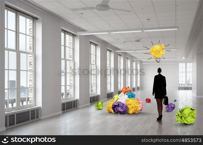 In search of inspiration. Elegant businesswoman in modern interior and balls of crumpled paper