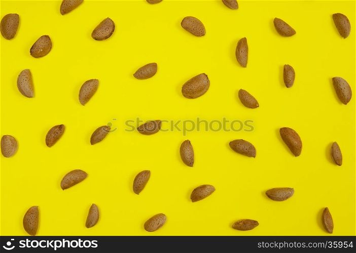 In shell raw almond on yellow background