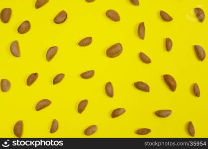 In shell raw almond on yellow background