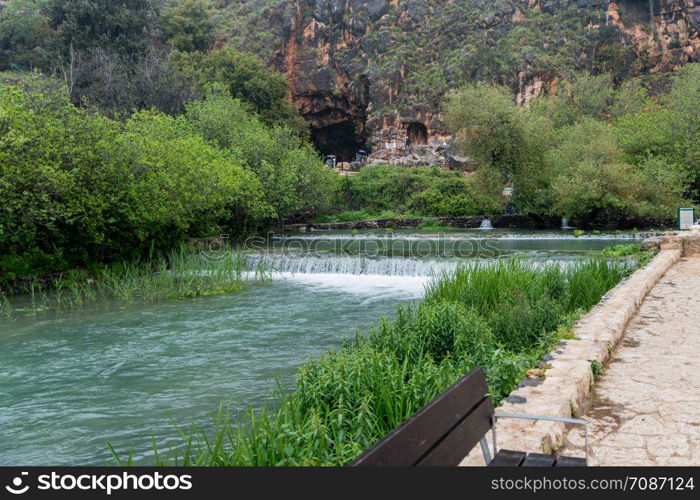 In the background of the Banias Spring is Pan&rsquo;s Cave, where the waterway originated in ancient times. the Banias Spring source of the jordan river