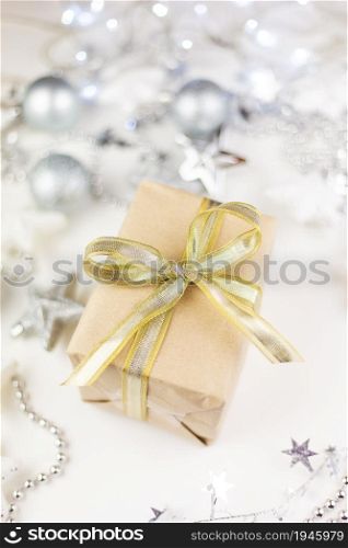 In the center of the assorted Christmas toys, there is a golden gift box created from kraft paper on a white background. In the center of the assorted Christmas toys, there is a golden gift box created from kraft paper on a white background.