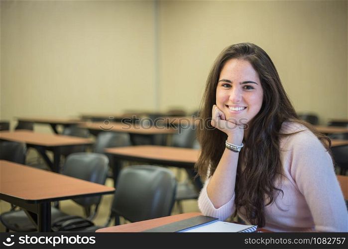 In the classroom - pretty female student with books working in a high school library.