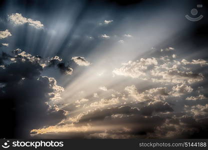 in the empty sky lots of clouds and sunny ray of light