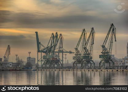 In the evening, the silhouette of port cranes.Ready to load containers from cargo ships.