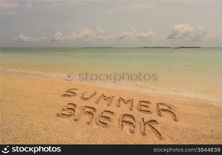 "In the photo a beach in Zanzibar in the afternoon where there is an inscription on the sand "Summer Break"."