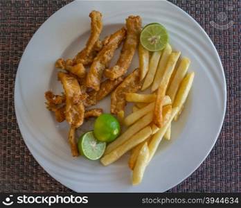 In the photo fried calamari served with fries and three lime as a garnish