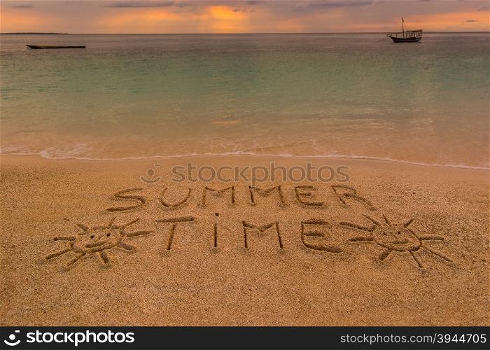 "In the picture a beach at sunset with the words on the sand "Summer time" ."