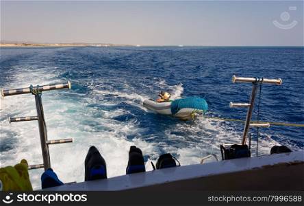 In the picture a moving ship , docked with a speedboat ,at forward hooked flippers and masks for snorkeling and in the background Egyptian coast .