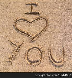 "In the picture an inscription on the sand "I love you"."