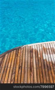 In the pictured curved wooden deck wet and in the background ocean blue / turquoise.