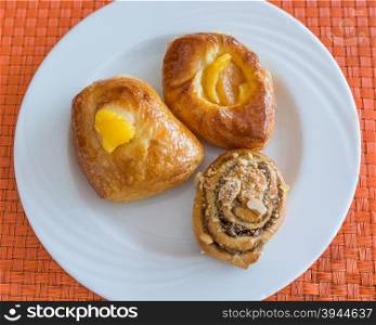 In the pictured three pastries served on a white plate .