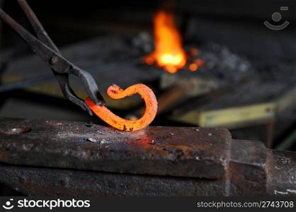 Incandescent element in the smithy on the iron anvil