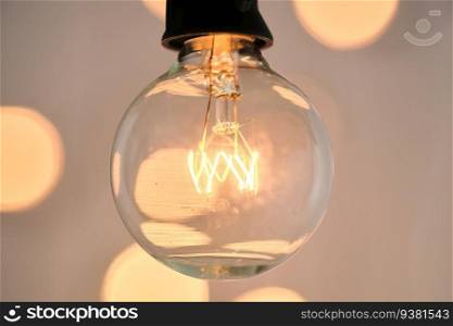 Incandescent light bulb with bokeh on background.. Incandescent light bulb with christmas round bokeh.