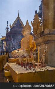 Incense offerings at a small shrine at the Buddhist temple of Wat Phra That Lampang Luang near Lampang in northern Thailand.