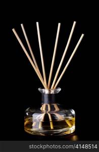 Incense sticks in a glass jar over black