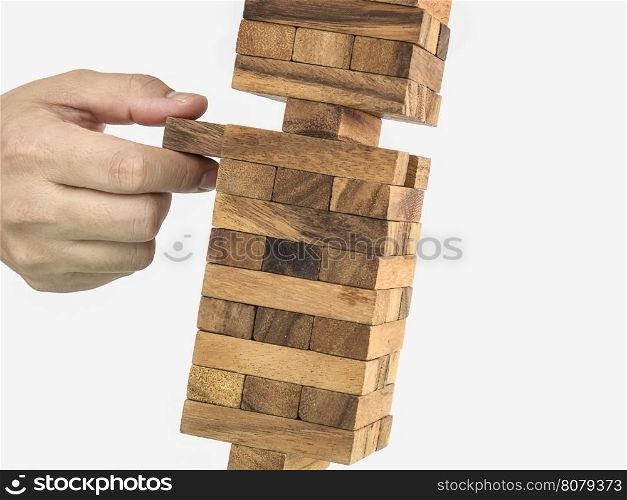 Inclined wooden block tower jenga game with hand, risk concept